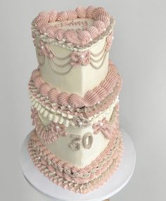 a three tiered cake with pink and white decorations