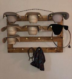 a bunch of hats are hanging on a wall with hooks and cords attached to it