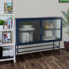 a large bird cage sitting on top of a wooden floor next to a book shelf