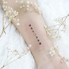 a woman's arm with three phases of the moon on it