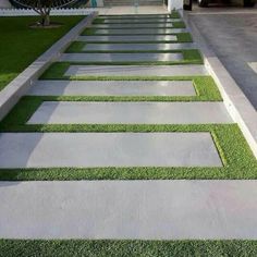 an outdoor walkway with grass and stepping stones