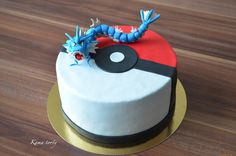 a pokemon cake is decorated with blue and red decorations on a wooden table, ready to be eaten