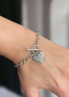 No Tarnish ~ Stainless Steel HEART Toggle Bracelet ~ love you to the moon ~ Stamped Heart Pendant ~ Heart Charm Bracelet ~ Silver Cable Chain ~ Women Teen Girl's Jewelry ~ Gifts For Her ~ Fun Fashion On The Go * 304 stainless steel * Lengths:   6.25";  6.5";  6.75";  7";  7.25";  7.5";  7.75";  8";  8.25";  8.5";  8.75";  9";  9.25";  9.5";   9.75";  10";  10.25";  10.5";  10.75";  11";  11.25";  11.5"  ( measurements include ring, bar & chain - SCROLL DOWN FOR MEASUREMENT TIPS!! ) * Width:  5mm; unsoldered links * Pendant:  15mm x 17mm * Toggle closure; no slip through longer bar * Tarnish resistant; waterproof  MEASUREMENT TIPS:  Measure your wrist with a flexible fabric tape measure. Do NOT choose length the same size as your wrist...it will not fit!   --->  For a tight, snug fit, choos Metal Heart Bracelet With Toggle Clasp, Valentine's Day Gift Bracelet With Toggle Clasp, Valentine's Day Heart Bracelet With Toggle Clasp, Heart Shaped Bracelet With Toggle Clasp As Gift, Heart-shaped Charm Bracelet With Toggle Clasp As Gift, Valentine's Day Gift Heart Bracelet With Toggle Clasp, Heart Charm Bracelet With Toggle Clasp For Gift, Heart Shaped Toggle Clasp Bracelet For Gift, Metal Heart Bracelet With Toggle Clasp As Gift