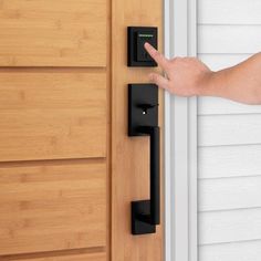 a person's hand is pointing at the door handle