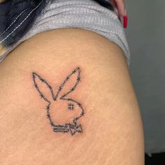 a tattoo on the back of a woman's thigh that has barbed wire and a bunny face