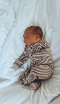 a baby is sleeping on a white sheet