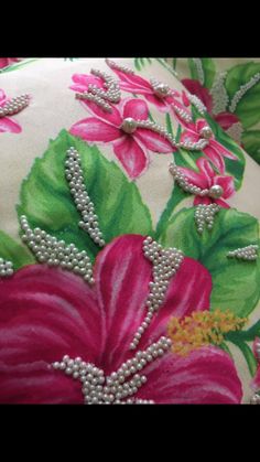 a decorative pillow with pink flowers and green leaves