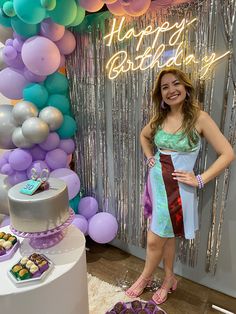 a woman standing in front of a birthday cake