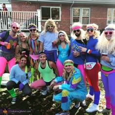 a group of people dressed up in costumes posing for a photo on the front lawn