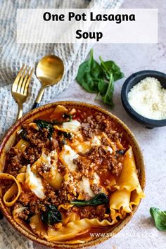 one pot lasagna soup in a bowl with spinach and cheese on the side