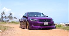 a purple car parked on the side of a dirt road