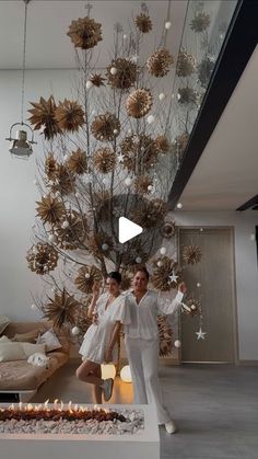 two people standing in front of a fire place with decorations on the wall behind them