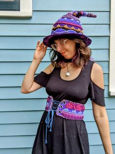 a woman wearing a purple hat and black dress