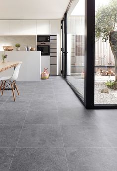 a modern kitchen and dining room with concrete flooring