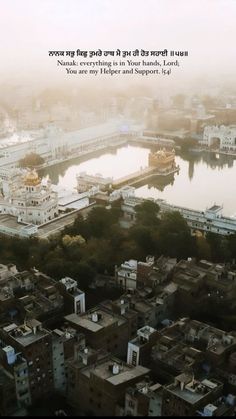 an aerial view of a city with lots of buildings and water in the background that is foggy