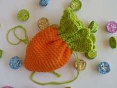 an orange crocheted bag sitting on top of a table next to candy candies