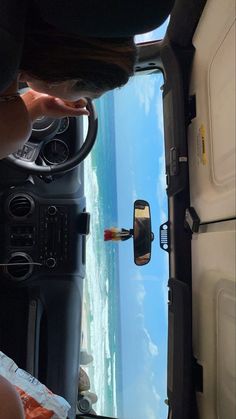 the view from inside an airplane looking down at the wing and dashboard, with one person holding a steering wheel