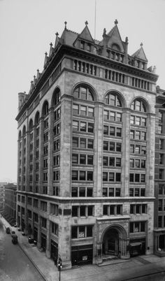 an old black and white photo of a large building with many windows on the top