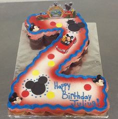 a birthday cake with mickey mouse numbers on it