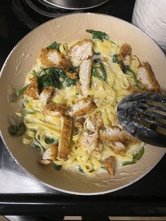 a pan filled with pasta and chicken on top of a stove