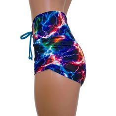 High-waisted booty shorts made in sparkle cosmic thunder UV Glow print stretchy performance spandex with ruching on the sides and lace-up detail in front. Made to flatter your figure and move with you. These booty shorts shine in different colors in the light - for a true holographic effect. The standard inseam is 2.5" - but can be customized. Sporty Fitted Shorts With Tie-side Bottom, Fitted Tie-side Swimming Shorts, Fitted Sports Shorts With Drawstring, Fitted Tie-side Workout Bottoms, Fitted Sports Bottoms With Drawstring, Sporty Fitted Tie-side Bottoms, Fitted High Waist Drawstring Shorts, Fitted Drawstring Shorts, Fitted Rave Bottoms With Built-in Shorts