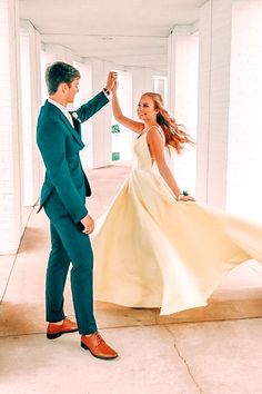 a man in a green suit and woman in a white dress holding hands with each other