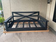 a black metal bed frame sitting on top of a porch