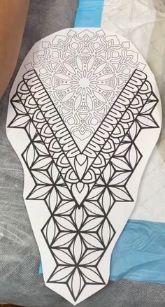 an intricately designed piece of paper sitting on top of a bed