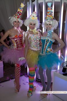 three women dressed in costumes standing next to each other