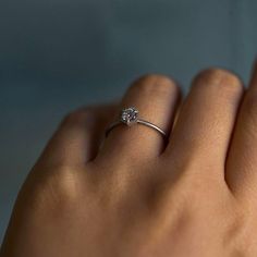 a woman's hand with a diamond ring on it