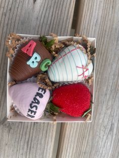 a box filled with chocolate covered strawberries on top of a wooden table