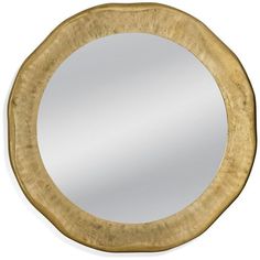 a round mirror with gold paint on it's edges and a circular frame around the edge