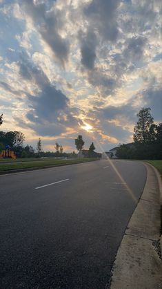 the sun is setting on an empty street