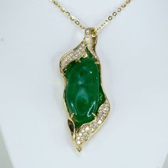 Discover the allure of our unique and elegant designer pendant. This extraordinary piece showcases a large natural Colombian cabochon emerald, exquisitely adorned with round brilliant cut diamonds. The diamonds, beautifully accentuate the breathtaking emerald. Crafted in 14K yellow gold, this pendant is a testament to exceptional craftsmanship and timeless elegance. Make a statement with this one-of-a-kind masterpiece that effortlessly captures attention and admiration. SPECIFICATIONS: 1982658 Gemstone: Natural Colombian Emerald, cabochon. Weight: 17.0ct.  Side Stones: 0.65ct of various sizes round brilliant cut diamonds. Colour: F G. Clarity: SI Material: 14K yellow gold. Total Weight: 13.34 grams. Dimensions: 50.0 x 21.0mm approx. Our family-owned business consists of gemmologists, miner Diamond Cabochon Pendant Necklace, Diamond Cabochon Necklace For Anniversary, Exquisite Green Jewelry With Pave Setting, Luxury Green Cabochon Jewelry, Luxury Emerald Pendant Necklace With Diamond Accents, Luxury Jade Necklace For Anniversary, Luxury Jade Pendant Jewelry, Exquisite Emerald Jewelry With Cabochon, Exquisite Emerald Cabochon Jewelry