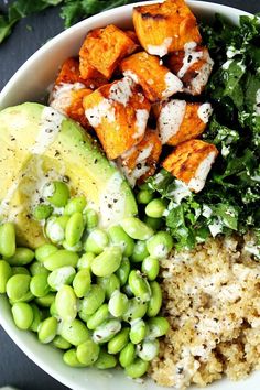 a white bowl filled with rice, peas and tofu next to broccoli