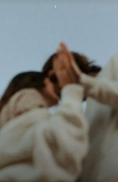 a woman in a white coat is covering her face