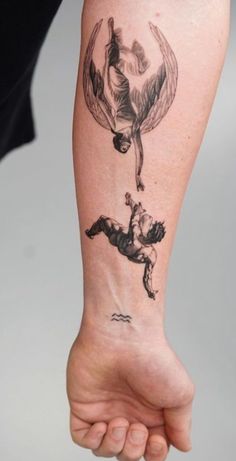 a person with a tattoo on their arm that has an image of two people flying