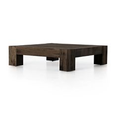 a square wooden table sitting on top of a white floor with no one around it