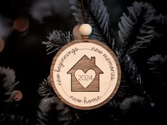 a wooden ornament hanging from a christmas tree with a house and heart on it