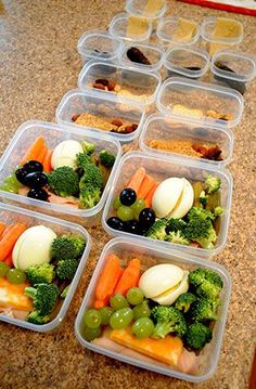 six plastic containers filled with food on top of a counter next to utensils