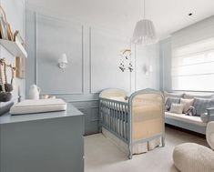 a baby's room with blue walls and white furniture