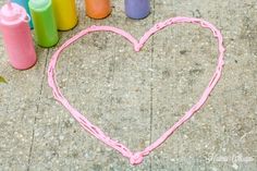 a heart made out of crayons sitting on the ground next to other crayons