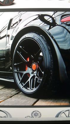 a car parked on the side of a road with its wheels painted black and red