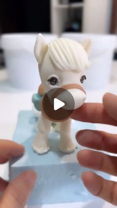 someone is holding a tiny toy horse in their hand and pointing it at the camera