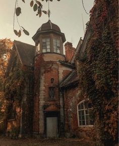 an old brick building with ivy growing on it's sides and a clock tower at the top