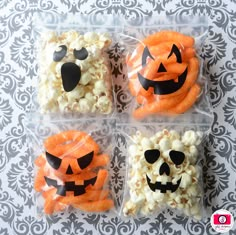 four plastic bags filled with halloween treats on top of a table