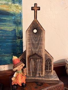 a small statue of a church with a cross on the top and an orange hat