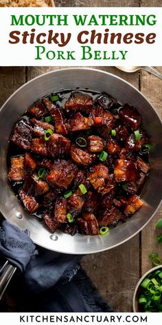 a bowl filled with sticky chinese pork bellys and green onions on top of a wooden table