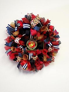 the wreath is made up of red, white and blue ribbons with an emblem on it