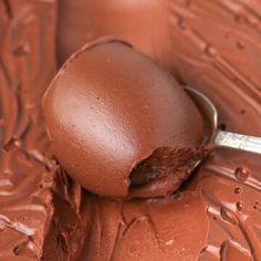 an egg is sitting on top of chocolate with a spoon sticking out of its shell